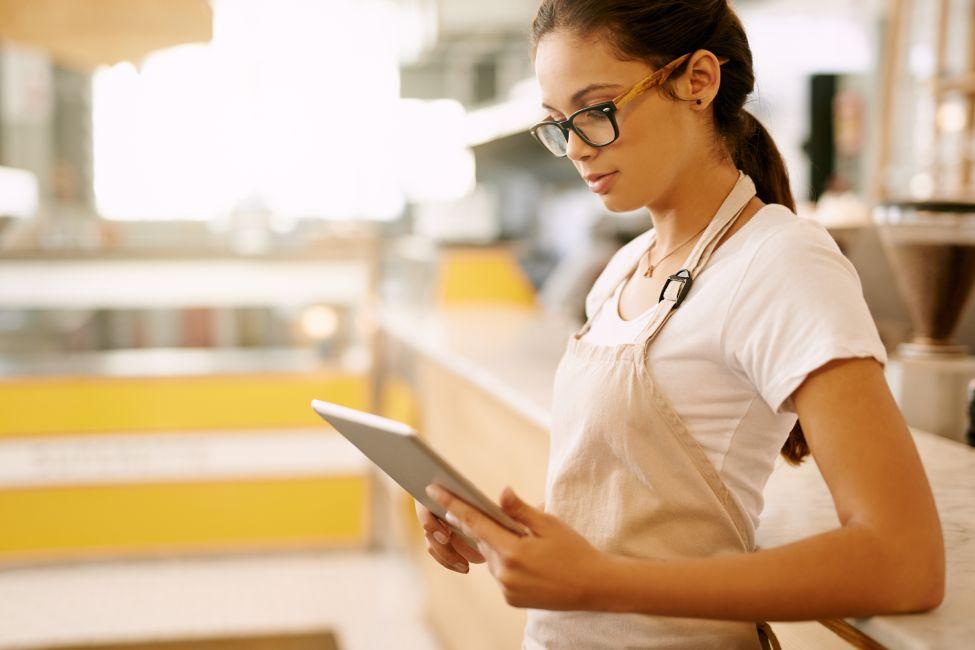 Mujer con delantal sujetando tablet