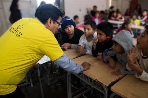 Trabajador de la Fundación Prosegur hablando con niños Trabajador de la Fundación Prosegur hablando con niños