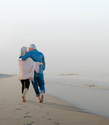 Pareja mayor paseando por la playa Pareja mayor paseando por la playa